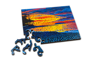 Mini wood jigsaw puzzle by Mike Lathrop featuring an island of elements design, with colorful puzzle pieces assembled on a wooden surface.